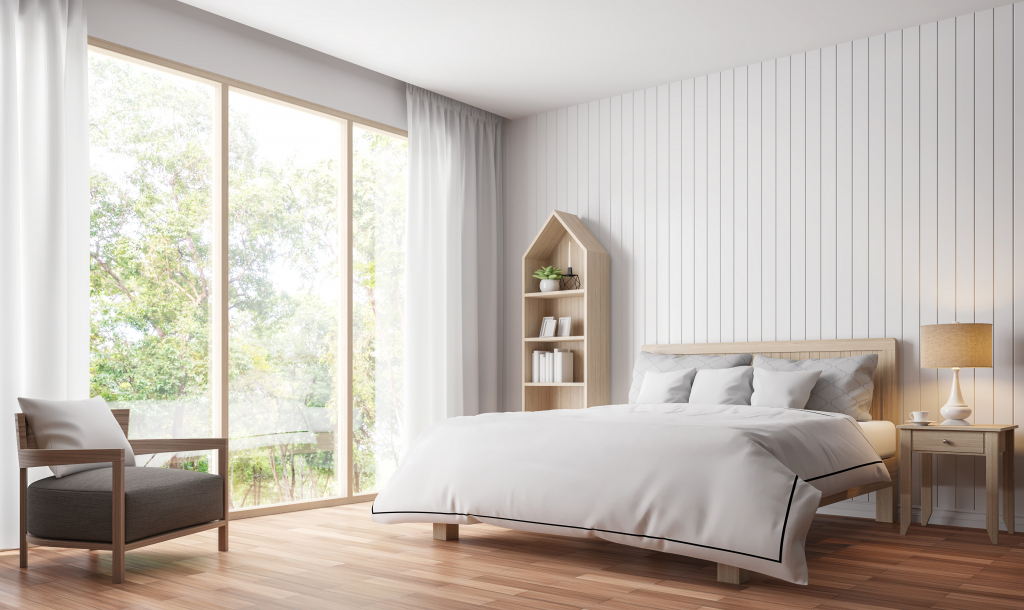 Gérer la luminosité dans une chambre en installant une grande baie vitrée.