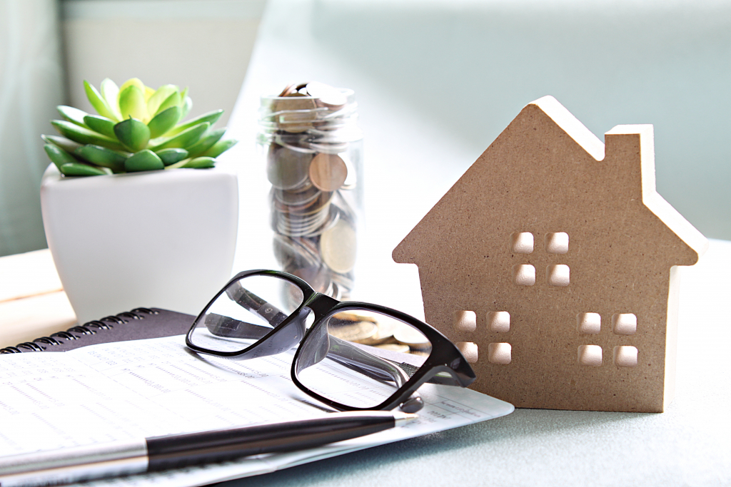 Maisonnette en bois, lunettes de vue, stylo et pièces de monnaies