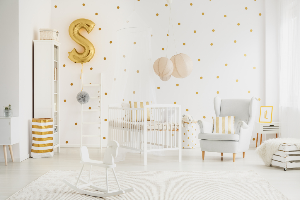 Décoration blanche avec des touches de doré dans la chambre de bébé