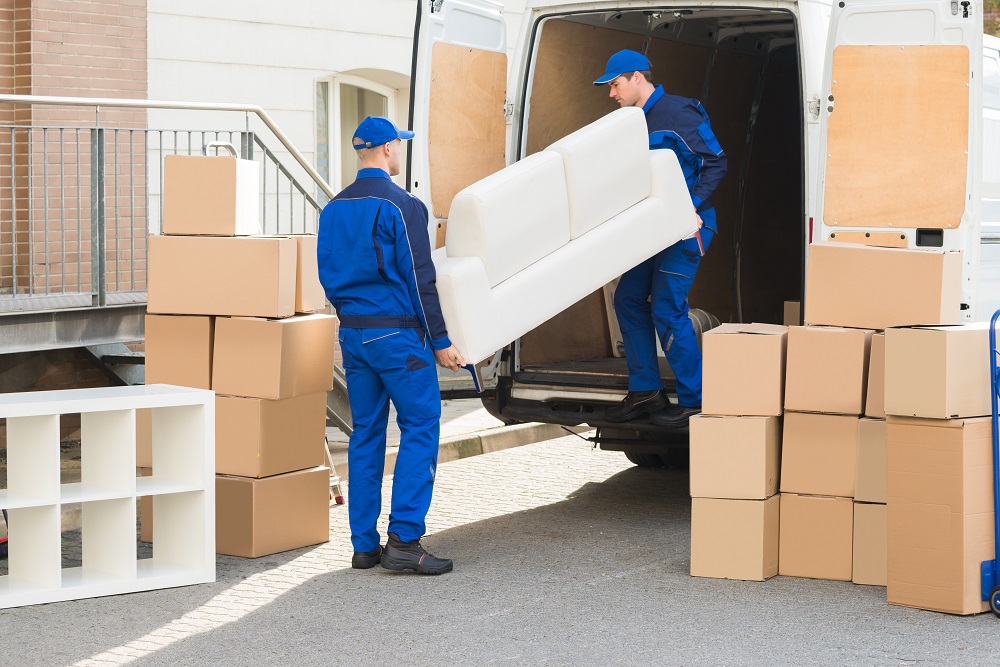 Des déménageurs professionnels organisent les meubles et les cartons dans le camion.