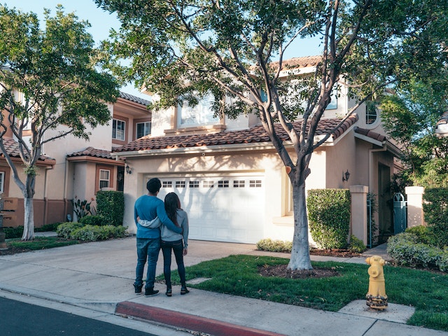 Un couple devant la maison qu'ils viennent d'acheter. 