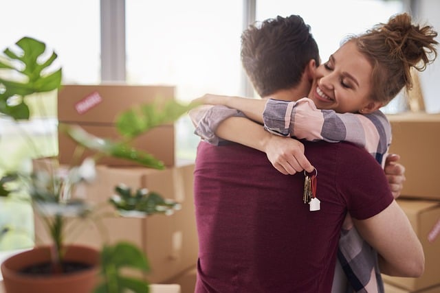 Un jeune couple se réjouit de son déménagement. Pour un achat immobilier serein, il ne faut pas oublier les dépenses supplémentaires liées au déménagement. 